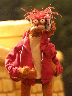 an image of the Muppet Pepe the King Prawn, dressed in nice clothes and holding a cellular telephone.